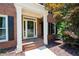 Charming front porch with brick steps and white columns, perfect for relaxing at 672 Red Sunset Cir, Powder Springs, GA 30127