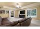 Cozy living room with a leather couch, large screen television, and a tray ceiling at 672 Red Sunset Cir, Powder Springs, GA 30127