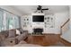 Cozy living room with built-in shelves, fireplace, hardwood floors, and plentiful natural light at 672 Red Sunset Cir, Powder Springs, GA 30127