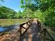 Scenic view of a pond with a wooden bridge surrounded by lush greenery, a peaceful escape to nature at 672 Red Sunset Cir, Powder Springs, GA 30127