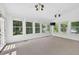 Bright sunroom with multiple windows, ceiling fans, and neutral carpet at 672 Red Sunset Cir, Powder Springs, GA 30127