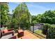 Private balcony with comfortable seating overlooking lush greenery and a peaceful neighborhood street at 11271 Calypso Dr, Alpharetta, GA 30009