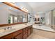 Luxurious bathroom features a double vanity, a large mirror, a soaking tub, and a glass shower at 11271 Calypso Dr, Alpharetta, GA 30009