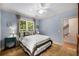 Comfortable bedroom bathed in soft light features neutral walls and a window overlooking foliage at 11271 Calypso Dr, Alpharetta, GA 30009