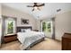 Bright bedroom features large windows, a ceiling fan, neutral colors, and a comfortable-looking bed at 11271 Calypso Dr, Alpharetta, GA 30009