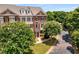 Three story brick home surrounded by white flowering trees and shrubs at 11271 Calypso Dr, Alpharetta, GA 30009