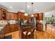Well-lit kitchen features an island gas range, granite counters, stainless appliances, and abundant cherry cabinets at 11271 Calypso Dr, Alpharetta, GA 30009
