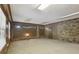 Spacious basement area featuring wood paneled walls, brick accents, and plush carpet at 1194 Robert Ln, Marietta, GA 30062