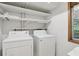 Functional laundry area featuring a washer, a dryer, and storage shelves at 1194 Robert Ln, Marietta, GA 30062