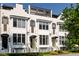 Classic white townhome featuring black framed windows, entry awnings, and manicured landscaping at 144 Northern Ave, Decatur, GA 30030