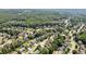 Aerial view of a residential neighborhood showcases a community surrounded by lush greenery and mature trees at 558 Grand Ivey Pl, Dacula, GA 30019