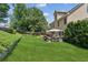 A spacious backyard features a patio with an umbrella-covered dining table and a nicely landscaped lawn at 558 Grand Ivey Pl, Dacula, GA 30019