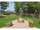 Landscaped backyard featuring a stone patio with a fire pit, seating, and lush greenery at 558 Grand Ivey Pl, Dacula, GA 30019