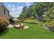 Large backyard with a stone fire pit, patio furniture, and well-maintained lawn at 558 Grand Ivey Pl, Dacula, GA 30019