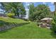 Scenic backyard featuring a tiered lawn, mature trees and an outdoor dining area at 558 Grand Ivey Pl, Dacula, GA 30019