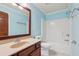Bathroom with granite countertop, stained wood vanity, and standard toilet/shower combination at 558 Grand Ivey Pl, Dacula, GA 30019