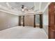 Spacious bedroom with a tray ceiling, neutral carpeting and abundant natural light at 558 Grand Ivey Pl, Dacula, GA 30019