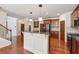 Open kitchen with a center island, stainless steel appliances, and dark wood cabinets at 558 Grand Ivey Pl, Dacula, GA 30019