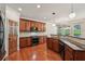 Lovely kitchen boasts stainless appliances, granite counters and dark-stained cabinets at 558 Grand Ivey Pl, Dacula, GA 30019