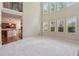 Bright open-concept living room with tall windows and a view of the kitchen and upstairs area at 558 Grand Ivey Pl, Dacula, GA 30019