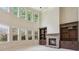 Bright living room with a fireplace, built-in shelves, tall windows, and high ceilings at 558 Grand Ivey Pl, Dacula, GA 30019