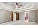 A spacious carpeted main bedroom features a decorative ceiling and doorway entrances to the walk-in closet and bathroom at 558 Grand Ivey Pl, Dacula, GA 30019