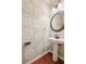 Elegant powder room with pedestal sink, decorative mirror, and charming patterned wallpaper at 558 Grand Ivey Pl, Dacula, GA 30019
