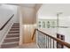 Bright staircase with carpeted steps, decorative iron railing, and large window at 558 Grand Ivey Pl, Dacula, GA 30019