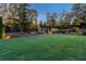 Beautifully landscaped backyard with tiered landscape beds and exterior lighting at 7048 Bennington Ln, Cumming, GA 30041