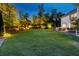 Spacious backyard with a large grassy area and professionally landscaped gardens at 7048 Bennington Ln, Cumming, GA 30041