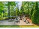 Outdoor space with a trampoline, stone patio, fire pit, chairs, and a privacy fence at 7048 Bennington Ln, Cumming, GA 30041