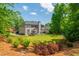 Expansive backyard with lush landscaping, a deck with patio furniture, and a well-maintained lawn at 7048 Bennington Ln, Cumming, GA 30041