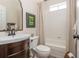 Bathroom features a white vanity with a framed mirror, tiled shower, and neutral color palette at 7048 Bennington Ln, Cumming, GA 30041