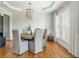 Bright dining room features a beaded chandelier, plantation shutters, and hardwood floors at 7048 Bennington Ln, Cumming, GA 30041