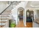 Foyer view showcasing hardwood floors, staircase with iron railing, and open layout to living spaces at 7048 Bennington Ln, Cumming, GA 30041