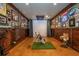 Bright home golf simulator with golf clubs, putting green, curtains and memorabilia at 7048 Bennington Ln, Cumming, GA 30041
