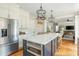 Open kitchen with stainless steel appliances, island with cooktop, and hardwood floors at 7048 Bennington Ln, Cumming, GA 30041