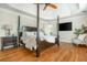 Primary bedroom with a four-poster bed, ceiling fan, and TV at 7048 Bennington Ln, Cumming, GA 30041