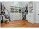 Spacious walk-in closet featuring custom shelving, drawers, and a round window, all complemented by hardwood flooring at 7048 Bennington Ln, Cumming, GA 30041