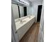 Bathroom featuring dual sinks, white cabinetry, and contemporary wood-look flooring at 1038 Island View Ct, Buford, GA 30518
