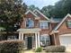Charming red brick two-story home featuring a well-manicured front yard and inviting front porch at 1038 Island View Ct, Buford, GA 30518