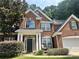 Charming red brick two-story home featuring a well-manicured front yard and inviting front porch at 1038 Island View Ct, Buford, GA 30518