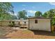 Back of the home featuring a wooden deck, patio, and a large backyard with mature trees at 5360 Fieldgreen Dr, Stone Mountain, GA 30088