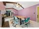 Bright dining room featuring high ceilings with exposed beams, a modern table, and colorful chairs at 5360 Fieldgreen Dr, Stone Mountain, GA 30088