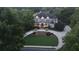 Aerial view of a two-story home with lush landscaping, circular driveway, and manicured front yard at dusk at 6325 Haddington Ln, Suwanee, GA 30024