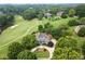 Gorgeous aerial view of a luxury home on a manicured lawn near a golf course and country club at 6325 Haddington Ln, Suwanee, GA 30024