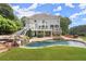 Stunning backyard with a waterfall feature, inviting pool, hot tub, outdoor kitchen, and comfortable seating area at 6325 Haddington Ln, Suwanee, GA 30024