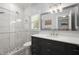 Updated bathroom featuring a glass shower, dark wood vanity, quartz countertop, and chrome fixtures at 6325 Haddington Ln, Suwanee, GA 30024