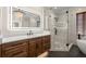 Bathroom vanity featuring an illuminated mirror, shaker cabinets, quartz countertop, and glass enclosed shower at 6325 Haddington Ln, Suwanee, GA 30024