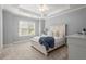 Bright bedroom with a tray ceiling, neutral carpet, and large window with natural light at 6325 Haddington Ln, Suwanee, GA 30024